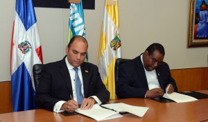 El administrador general del Banco de Reservas, Enrique Ramírez Paniagua, y el rector del Universidad Católica de Santo Domingo, Jesús Castro, firman el acuerdo de colaboración.