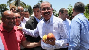 El presidente Medina con varios frutos producidos en unos de los campos visitados.