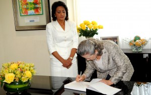 La primera Dama Cándida Montilla de Medina observa a Yoo Soon-taek cuandon firma el libro de visitas.