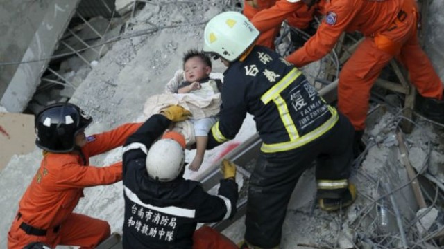 Brigadas rescatan a un niño de unos de los edificios derribados por el sismo.