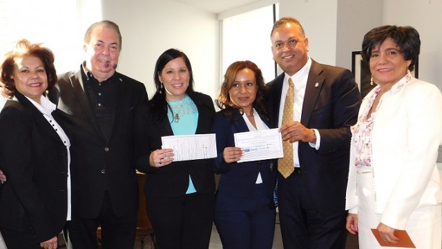 El cónsul Eduardo Selman a la izquierda, junto a Ana García Reyes, el diputado Rubén Luna y Miguelina Concepción, momento cuando el diputado Rubén Luna entrega dos becas de dos mil dólares cada una a las estudiantes Zeleny Castillo y Magdalena Díaz, de Hostos Community College