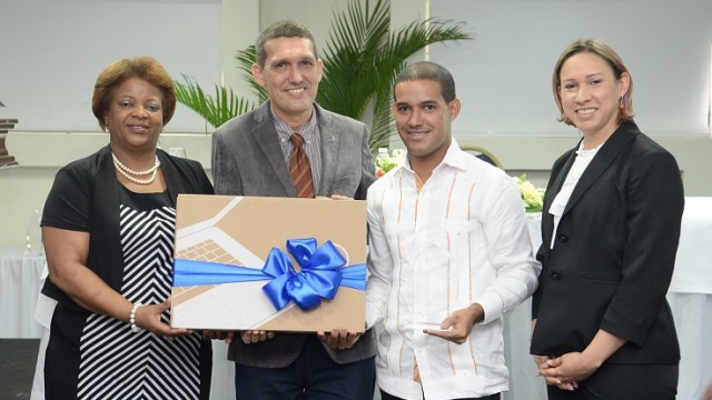 El docente Williams Francisco Jáquez Estévez recibe una placa y laptop