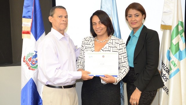 Oscar Enrique Villeta y Nurys González, técnicos del Inafocam entregan el certificado de participación a una de las docentes. 