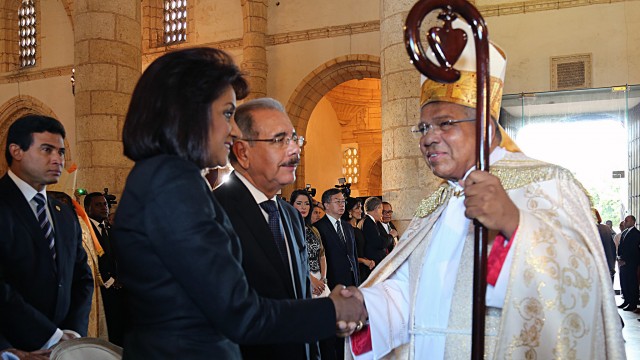 El nuevo arzobispo de Santo Domingo conversa con el presidente Medina y la Primera Dama, C{andida Montilla de Medina.