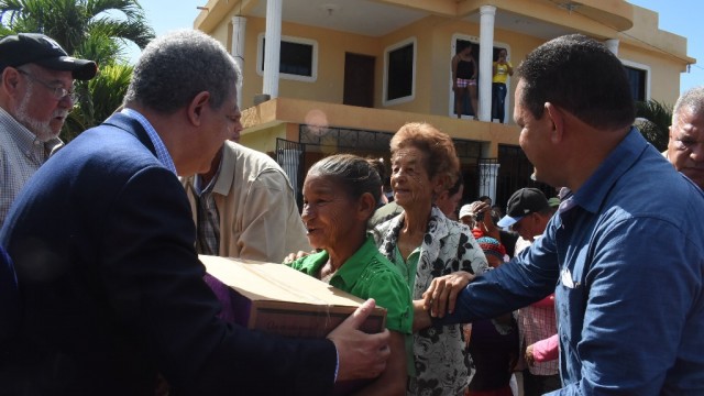 El presidente del PLD y ex presidente de la República, Leonel Fernández entrega canastas a residentes en zonas afaectadas por las lluvias.