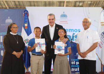 El presidente Luis Abinader entrega libro a estudiantes.